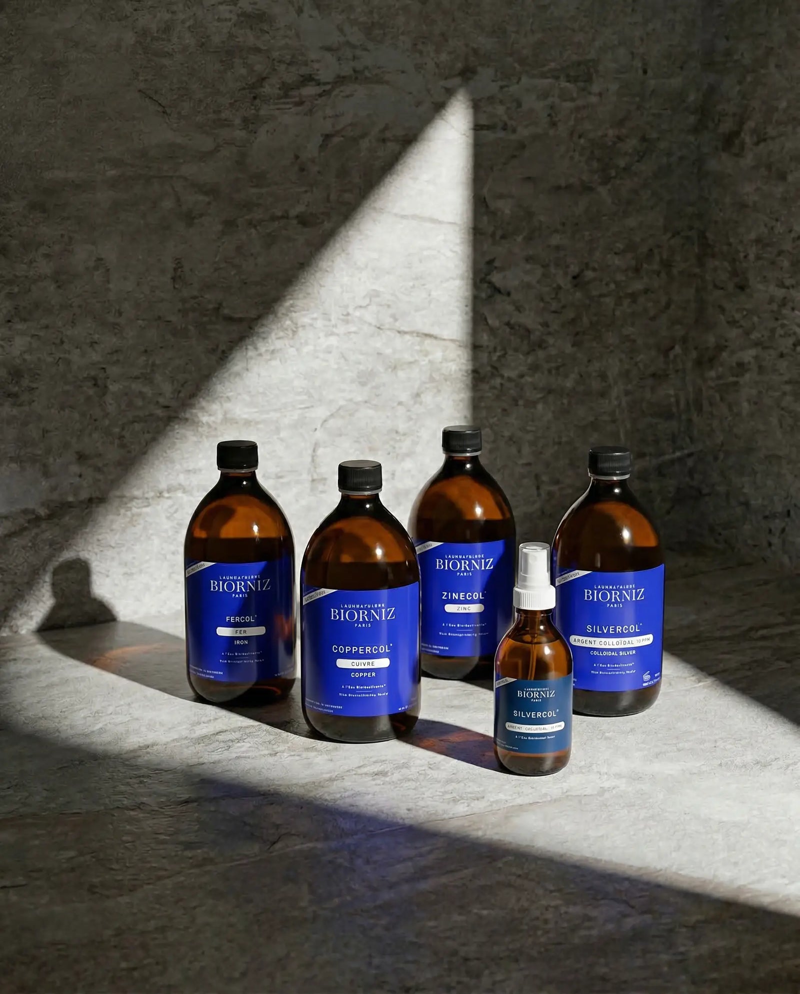 Gamme complète d'oligo-éléments incluant l'argent colloïdal 10 et 15 ppm, le zinc, le fer et le cuivre sur un fond minéral naturel.